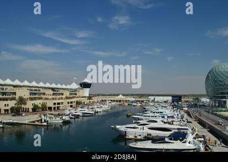 Une perspective lointaine du circuit Yas Marina, avec ses tribunes, ses villas d'équipe et ses gratte-ciel. Banque D'Images