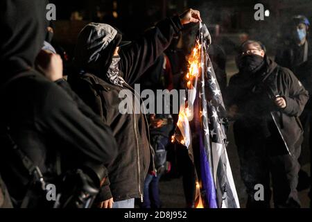 Les manifestants brûlent un drapeau « Blue Lives Matter ». Environ 50 manifestants ont défilé du parc Laurelhurst au bureau du shérif du comté de Multnomah (CSO) pour se rassembler contre les brutalités policières et les meurtres de Noirs, au cours du sixième mois de manifestations à Portland, Oregon, le 29 octobre 2020. (Photo de John Rudoff/Sipa USA) crédit: SIPA USA/Alay Live News Banque D'Images