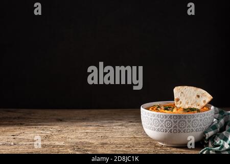 Houmous de citrouille dans un bol sur une table en bois. Espace pour copier Banque D'Images