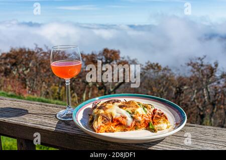 Gros plan de tranche de pizza sur l'assiette sur la terrasse du balcon Boisson au vin de rose rouge dans le jardin à l'extérieur de Blue Ridge montagnes avec brouillard brumeux au-dessus de la vue Banque D'Images