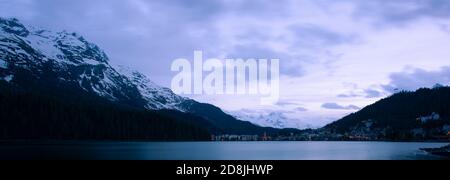 Un panorama nocturne de la station balnéaire haut de gamme de St Moritz, Suisse. Lumières de la ville, architecture, sommets alpins, vue sur la neige et le lac Banque D'Images