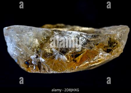 Quartz naturel citrine , pierre brute jaune sur fond noir. L'éclairage crée l'illusion d'un paysage de montagne à l'intérieur du cristal. Banque D'Images