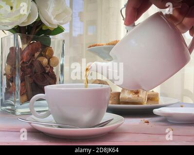 Verser le thé dans la tasse et les bonbons espagnols de noël comme cortadillos et gâteaux Banque D'Images