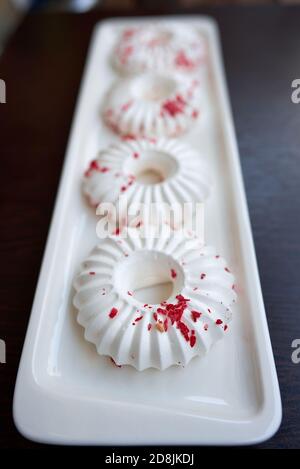 Quatre gâteaux blancs à la meringue avec chapelure rouge. Gros plan. Mise au point sélective Banque D'Images