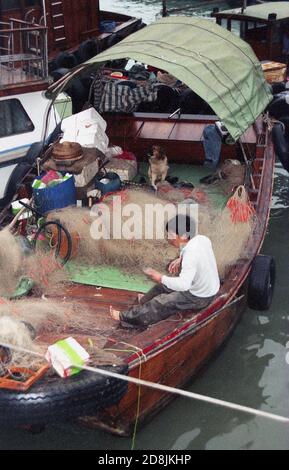 1987, février, historique, pêcheur chinois avec ses filets sur sa malbouffe traditionnelle dans le port d'Aberdeen, Hong Kong dans cette époque. Banque D'Images