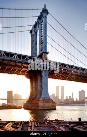 Le soleil se couche sur la ville de New York avec le pont de Manhattan en premier plan et le pont de Brooklyn en arrière-plan. Banque D'Images