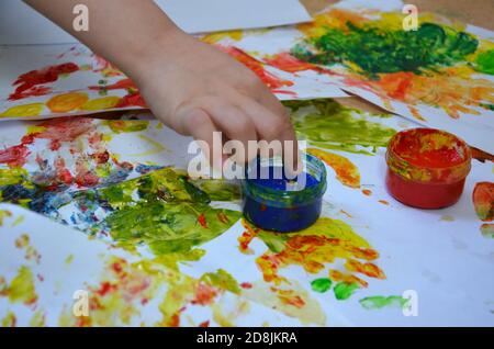 un enfant dessine. un enfant dessine des encres, des peintures à doigts, des empreintes à la main avec son doigt sur du papier blanc Banque D'Images