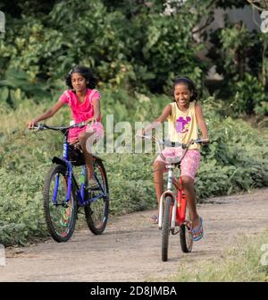 Province du Sud / Sri Lanka - 10 24 2020: Deux enfants font du vélo dans les rues rurales en appréciant et en souriant. Banque D'Images