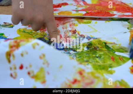 un enfant dessine. un enfant dessine des encres, des peintures à doigts, des empreintes à la main avec son doigt sur du papier blanc Banque D'Images