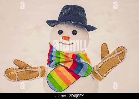 Charmant bonhomme de neige dans un village enneigé. Bonhomme de neige. Bonhommes de neige. Faire de la bonhomme de neige et de l'hiver. Joli petit bonhomme de neige en plein air. Banque D'Images