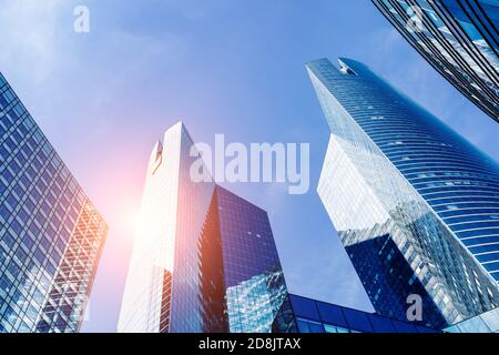 Immeubles de bureaux dans le quartier financier avec lumière du soleil et ciel reflétant dans les murs modernes de verre de gratte-ciel. Expérience professionnelle. Angle faible de v Banque D'Images