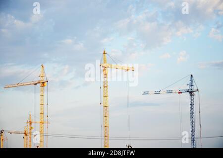 Place intérieure pour de nombreux grands bâtiments en construction et grues sous un ciel bleu travaillant sur des lieux avec de grandes maisons Banque D'Images