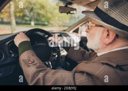 Gros plan profil vue latérale portrait de son beau expérience qualifié sérieux concentré confiant et confiant homme aux cheveux gris conduisant la voiture dans la circulation bourrage en cours Banque D'Images