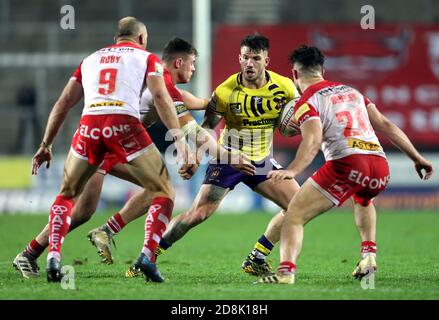 Oliver Gildart (au centre) de Wigan Warriors est affronté par James Roby (à gauche) de St Helens et James Bentley lors du match de la Super League de Betfred au stade de la méchante, St Helens. Banque D'Images