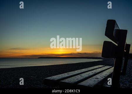 Banc en bord de plage au coucher du soleil sur la baie Banque D'Images