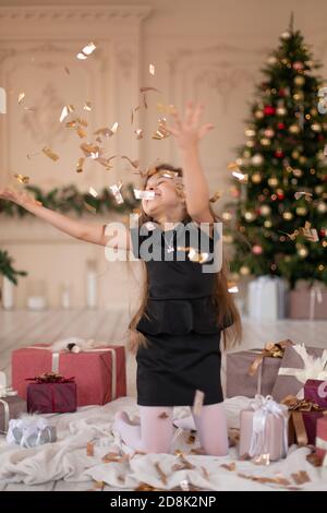 Petites filles jetés confetti. Magie de Noël. Des moments joyeux d'une enfance heureuse. Banque D'Images