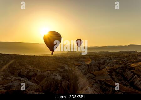 Ballons d'air chaud dans le ciel au lever du soleil à Goreme Cappadoce Banque D'Images