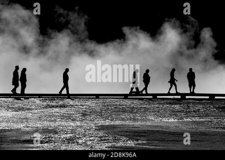 Silhouette des touristes de Yellowstone sur la promenade au-dessus des piscines geyser Banque D'Images