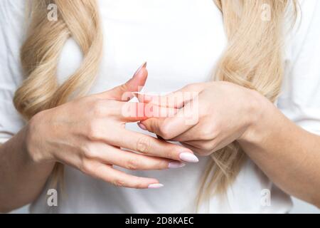 La femme ressent des douleurs articulaires dans les doigts, se massant pour les doigts après le travail sur ordinateur. Arthrose, syndrome du travail de bureau concept Banque D'Images