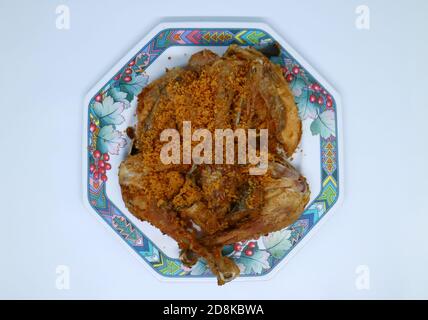 Poulet frit avec des flocons épicés croustillants sur fond blanc. Poulet frit indonésien ou ayam goreng kremes. Banque D'Images