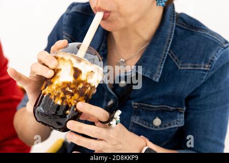 Femme appréciant son verre de caramel Bubble thé boba Banque D'Images