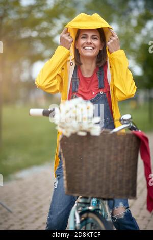 Femme à vélo par jour de pluie dans un parc Banque D'Images