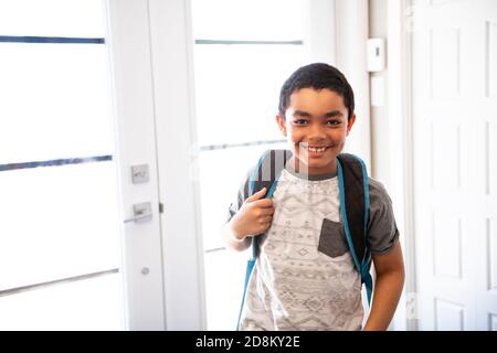 Un enfant qui rentre à la maison passe par la porte après école Banque D'Images