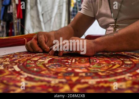 Cancun, Mexique. 30 octobre 2020. CANCUN, MEXIQUE - OCTOBRE 30: L'artisan Mario Garcia, fabrique un artisanat avec la conception de la pierre du Soleil généralement connu sous le nom Aztec Calendrier fait à la main avec des fibres Popotillo; 'Popotillo' est une technique pré-hispanique, où les fibres naturelles de millet sont utilisées pour créer un dessin. Les fibres multicolores précédemment peintes avec un procédé traditionnel sont tissées sur un arrière-plan créant une conception. Le 30 octobre 2020 à Cancun, Mexique. Crédit: Rodolfo Flores/Groupe Eyepix/l'accès photo crédit: L'accès photo/Alamy Live News Banque D'Images