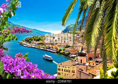 Limone sul Garda vue sur le front de mer à travers des fleurs et des palmiers, région Lombardie de l'Italie Banque D'Images