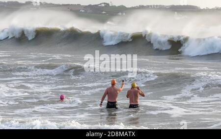 Myrtleville, Cork, Irlande. 31 octobre 2020. Trois nageurs regardent un film les vagues pendant Storm Aiden à Myrtleville, Co. Cork, Irlande.- Credit; David Creedon / Alay Live News Banque D'Images