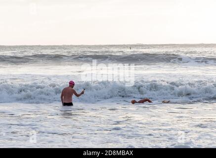 Myrtleville, Cork, Irlande. 31 octobre 2020. Un homme filme son ami nageant pendant Storm Aiden à Myrtleville, Co. Cork, Irlande. - crédit; David Creedon / Alamy Live News Banque D'Images