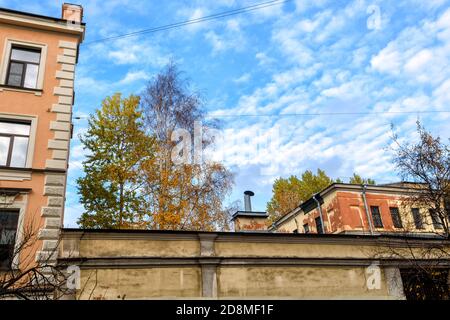 Vieux quartier résidentiel dans le centre de Saint-Pétersbourg, Russie. Bâtiments jaunes avec vieilles briques grises. Paysage urbain historique avec arbres d'automne Banque D'Images