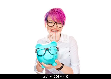 Bonne femme excitée par des économies sur l'achat de lunettes. La banque de porc et la fille portant des lunettes isolées sur fond blanc. L'ophtalmologie finance l'épargne Banque D'Images