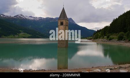 Célèbre tour d'église monodebout dans le réservoir de Reschensee, Tyrol du Sud, Italie en souvenir du village inondé de Graun, au début de l'été. Banque D'Images