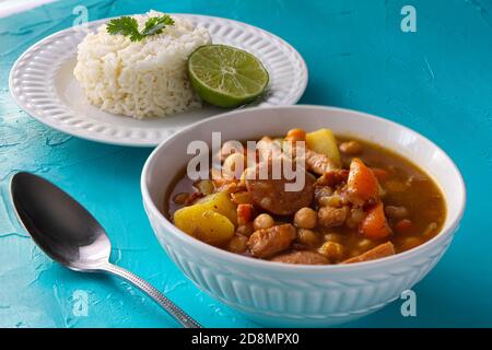 Rasez la soupe avec les légumes dans un bol et le riz blanc avec de la chaux sur une plaque sur une surface bleue Banque D'Images