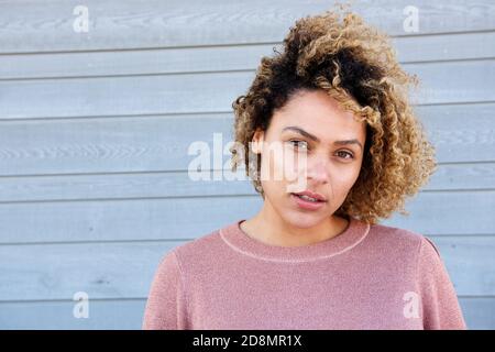 Gros plan portrait horizontal belle femme afro-américaine contre le gris mur Banque D'Images