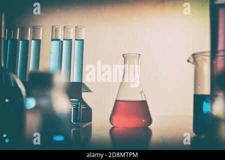 Banc de laboratoire de chimie avec flacon de liquide rouge et divers outils millésime. Vue avant. Composition horizontale. Banque D'Images