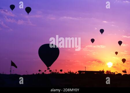 Silhouette de ballons d'air chaud dans le point de vue de Göreme au lever du soleil, Cappadoce, Turquie Banque D'Images