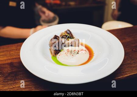 Le serveur est maintenant un plat délicieux rôti de viande juteuse, purée de pommes de terre saupoudrées de verts et frais sain salade de laitue et tomates Banque D'Images