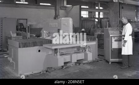 Années 1950, historique, un opérateur masculin debout par une unité de contrôle de la Bunker-Rand Corporation liée à une grande pièce de machines à bois fabriquées par Ekstrom-Carlson & Co de Rockford, ILL, USA, une société fondée en 1904. Banque D'Images