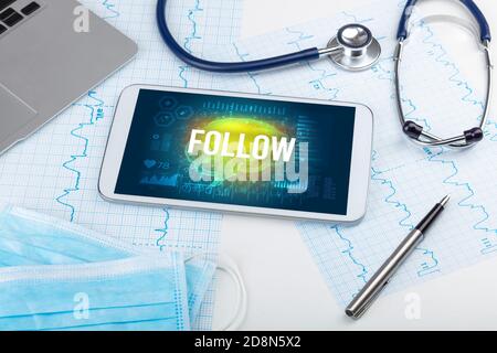 Tablette pc et outils médicaux avec inscription « FOLLOW », concept de distanciation sociale Banque D'Images