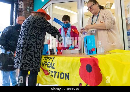 Ashford, Kent, Royaume-Uni. 31 octobre 2020. Les membres du public font un don à l'appel au pavot qui rencontre cette année des difficultés pour recueillir des dons en raison de la pandémie du coronavirus. Crédit photo: Paul Lawrenson-PAL Media/Alay Live News Banque D'Images