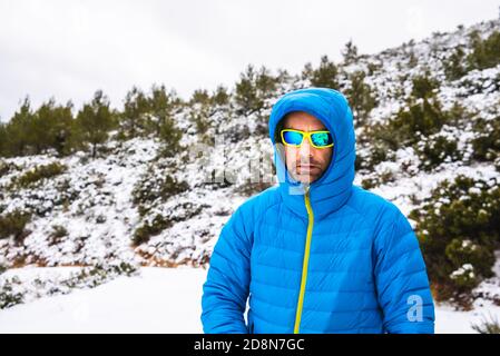 Le randonneur descend la montagne pendant une neige recouverte d'un manteau en duvet. Banque D'Images