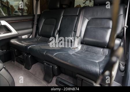 Sièges arrière de la voiture pour trois passagers dans le Arrière d'un vus recouvert de cuir noir avec le accoudoir rabattu avant nettoyage à sec et lavage Banque D'Images