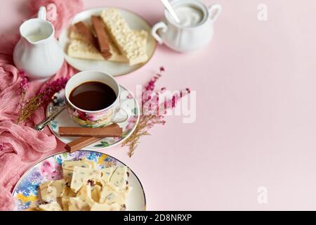 Chocolat chaud ou cacao dans la tasse avec divers bonbons sur les côtés. Barre de chocolat blanc et biscuits Banque D'Images