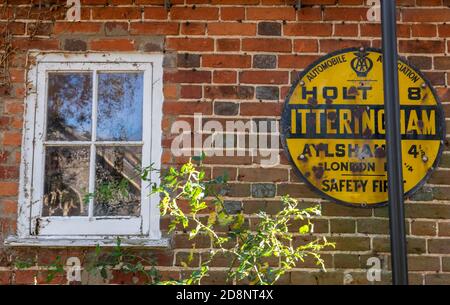 panneaux en émail d'époque sur le mur d'un vieux bâtiment historique en brique rouge dans le village de holt et d'itteringham de norfolk. panneau en émail d'époque d'olde worlde Banque D'Images