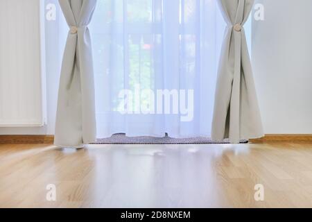 Détails intérieurs rapprochés, porte-balcon en verre avec rideaux blancs gris, plancher d'espace pour les copies Banque D'Images