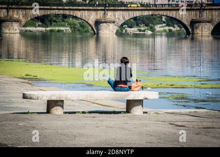 Assis sur un banc de la rivière po Banks Banque D'Images