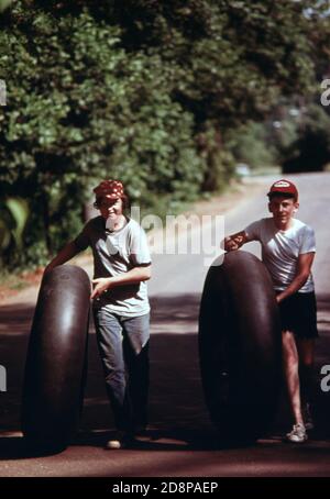 Deux jeunes avec des tubes intérieurs de camion se dirigent vers la rivière Chattahoochee le long de la rue escowee à Helen. Le tubing sur la rivière est un passe-temps favori pendant l'été. Helen était une petite communauté typique de montagne de quelque 270 personnes à 90 miles au nord-est d'Atlanta jusqu'en 1969. A cette époque, les hommes d'affaires et les résidents locaux ont approuvé la rénovation du quartier des affaires sur le thème des Alpes bavaroises Banque D'Images