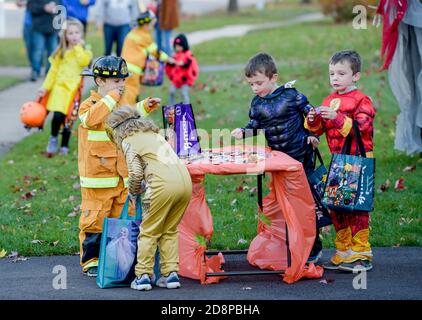 St. Charles, Illinois, États-Unis. 31 octobre 2020. Un groupe d'enfants en costume choisissent des bonbons à partir d'une table placée comme la fin d'une allée comme Covid-19 a modifié la façon dont les enfants ont exécuté leur tour annuel d'Halloween ou de traiter à St. Charles, il, le samedi 31 octobre 2020. Crédit : Mark Black/ZUMA Wire/Alamy Live News Banque D'Images